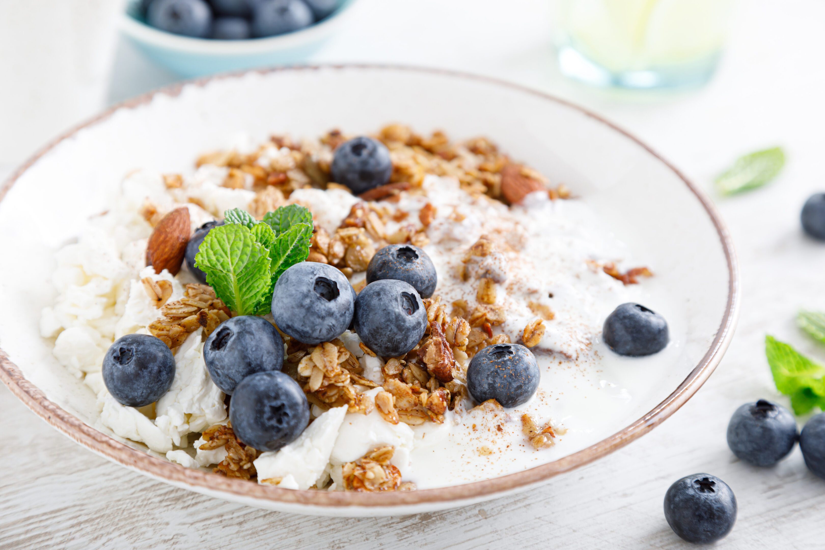 Bowl of granola with fresh blueberry, cottage cheese or curd, yogurt and nuts. Healthy food. Breakfast