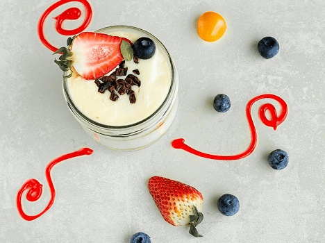 Yogurt parfait with berries and red drizzle.