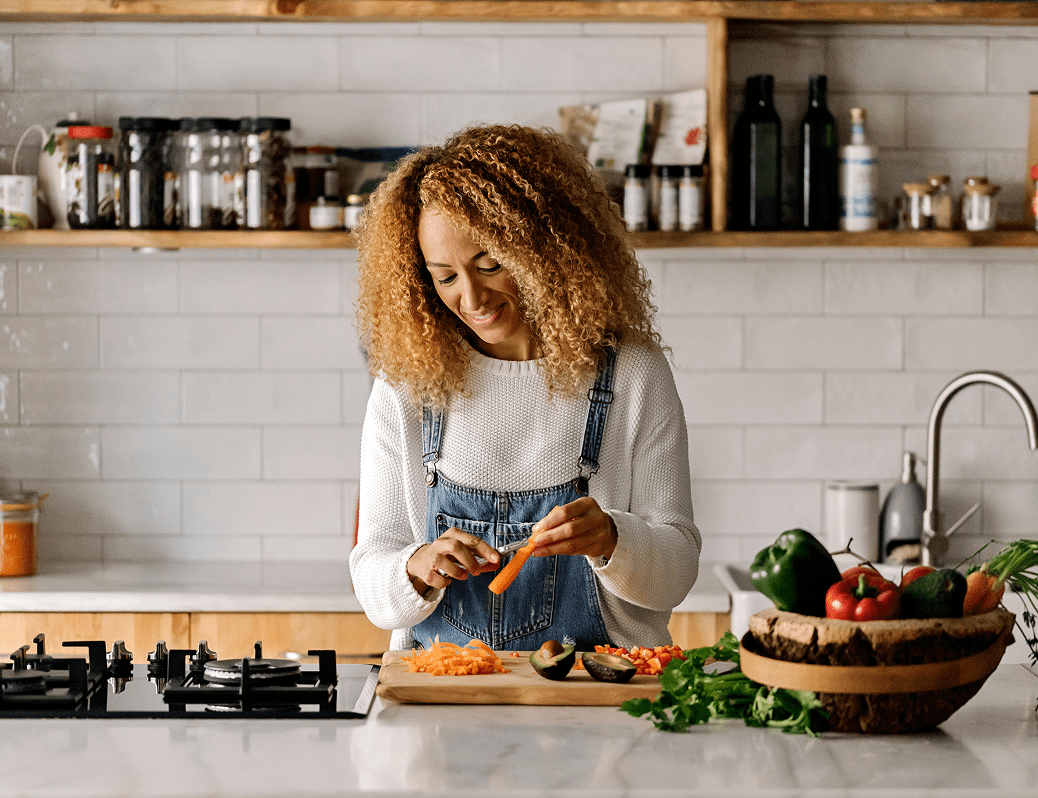 Woman chopping vegetables in a modern kitchen.