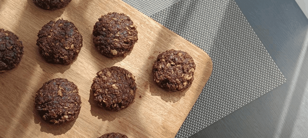 Chocolate cookies on a wooden cutting board.